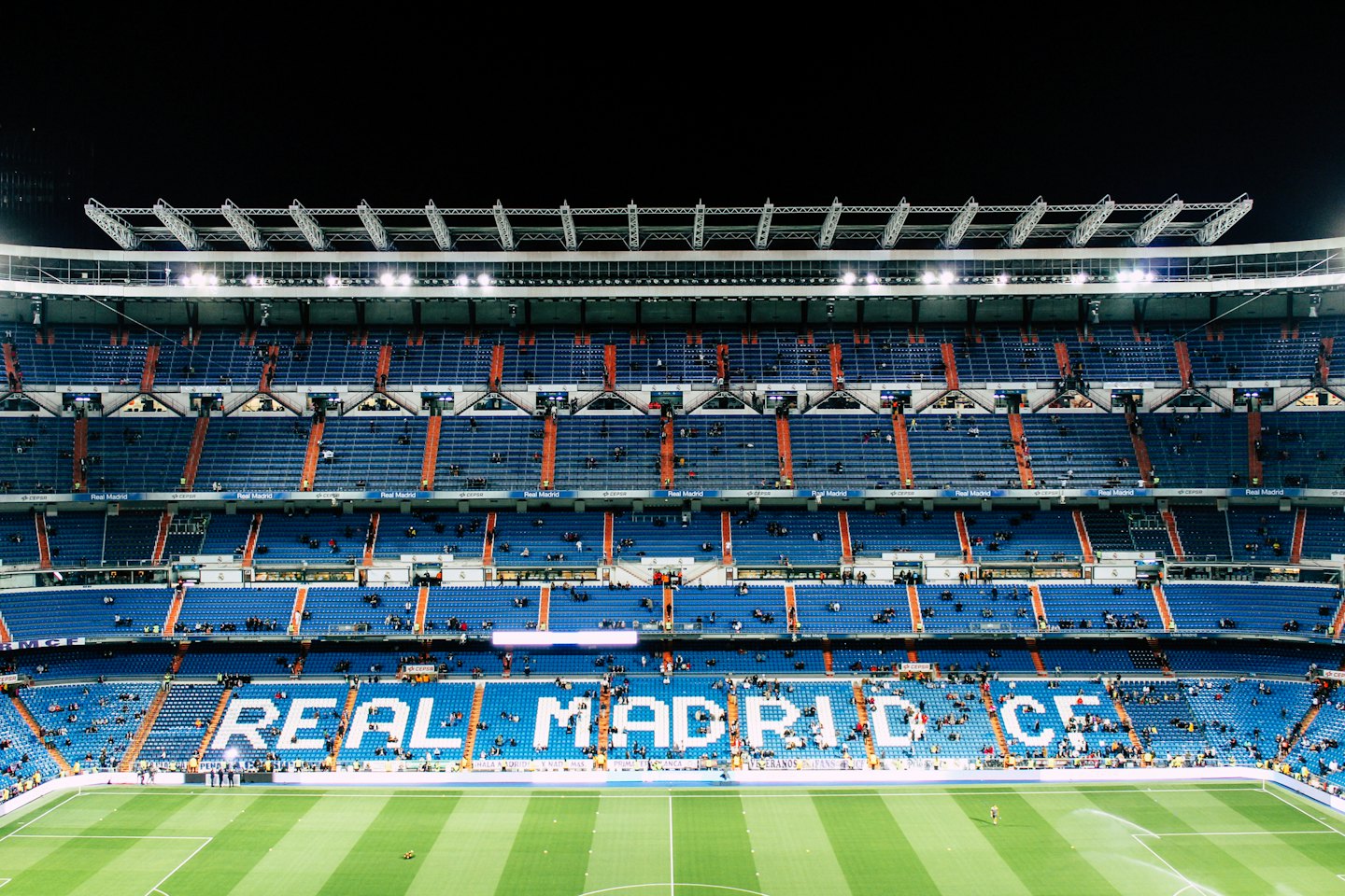 Estadio del Real Madrid vacío por la noche con luces brillantes.